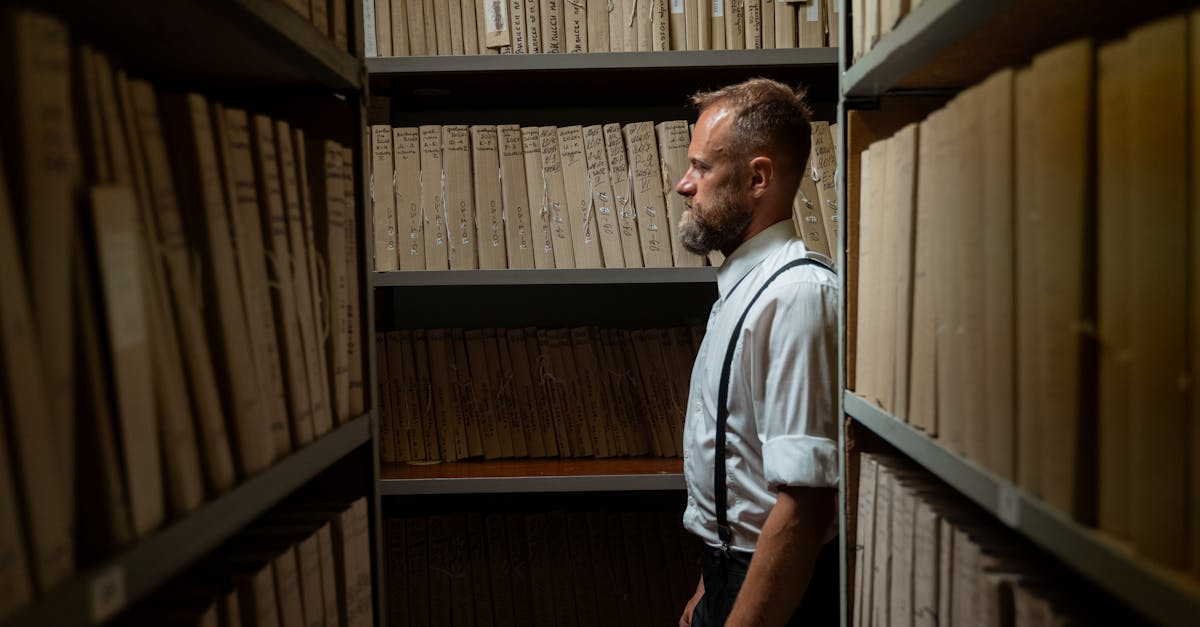 archiviste professionnel spécialisé dans la gestion, la conservation et l'organisation des documents et archives historiques pour assurer leur accessibilité et préservation.