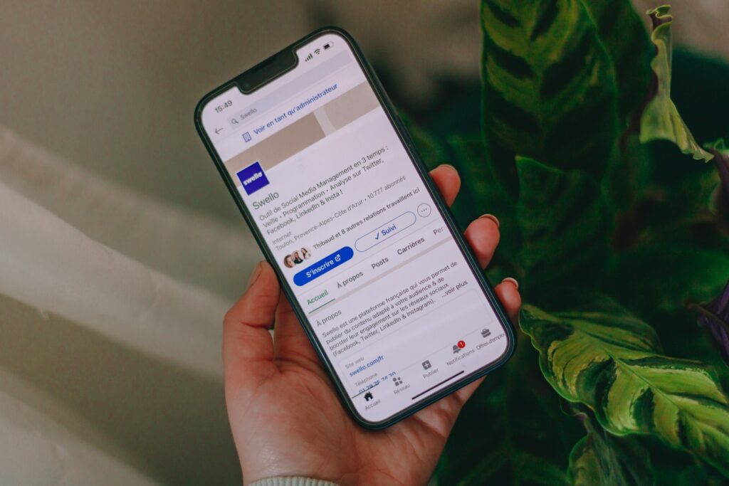 Pourquoi votre profil LinkedIn reste invisible alors que vous cherchez un emploi ? a person holding a cell phone in their hand