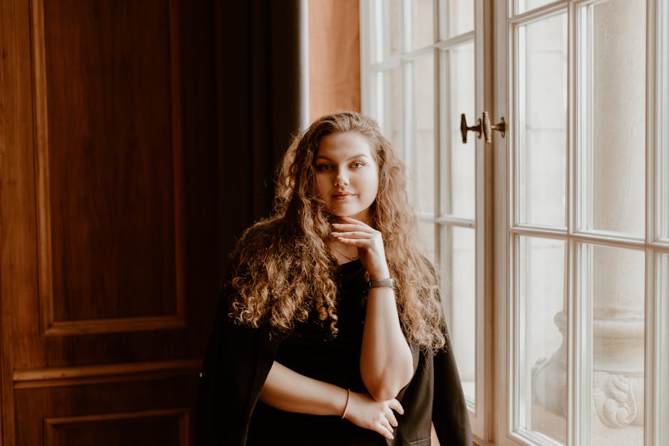 Person posing for a professional CV photo near a window with natural light