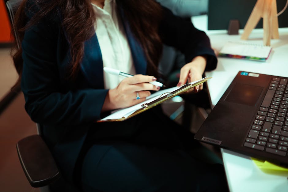 Personne préparant un entretien avec des notes et un ordinateur portable