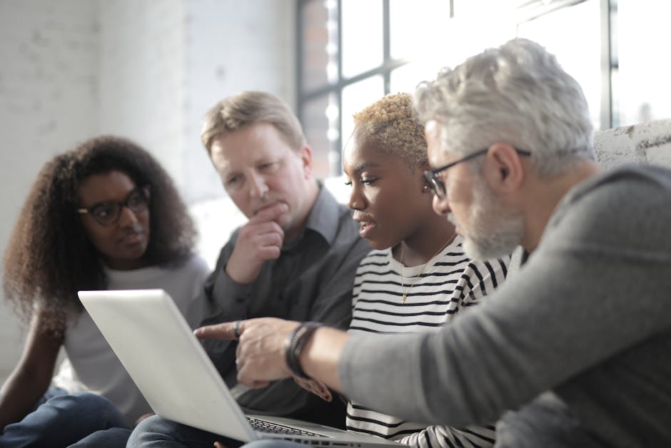 Professionals collaborating around a laptop in a modern office
