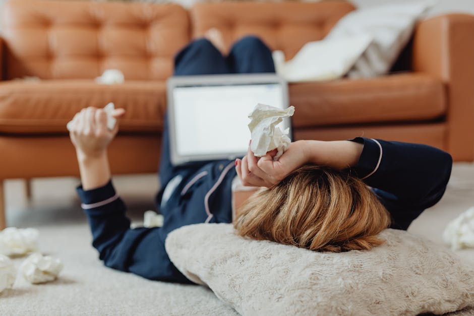 Sick employee resting at home with blanket and tissues