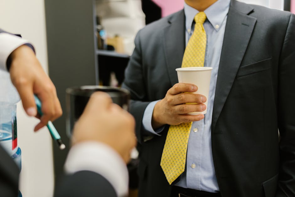 Colleagues discussing a referral over coffee in a workplace