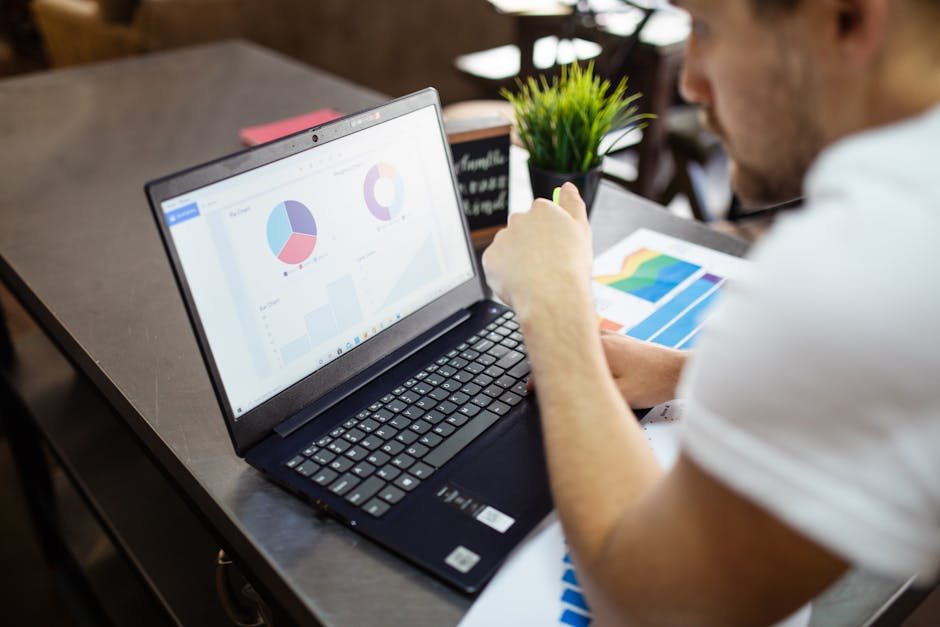 Professional working on a laptop with charts and data analysis