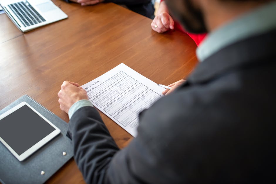 Manager reviewing a CV and cover letter on a laptop
