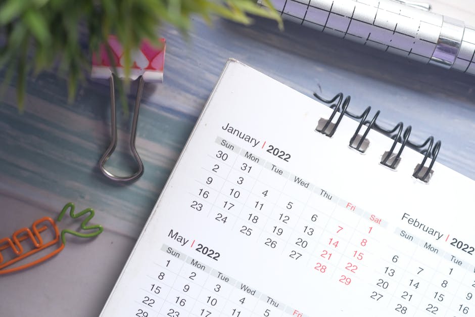 Close-up of a person drafting a professional email with notes and calendar visible