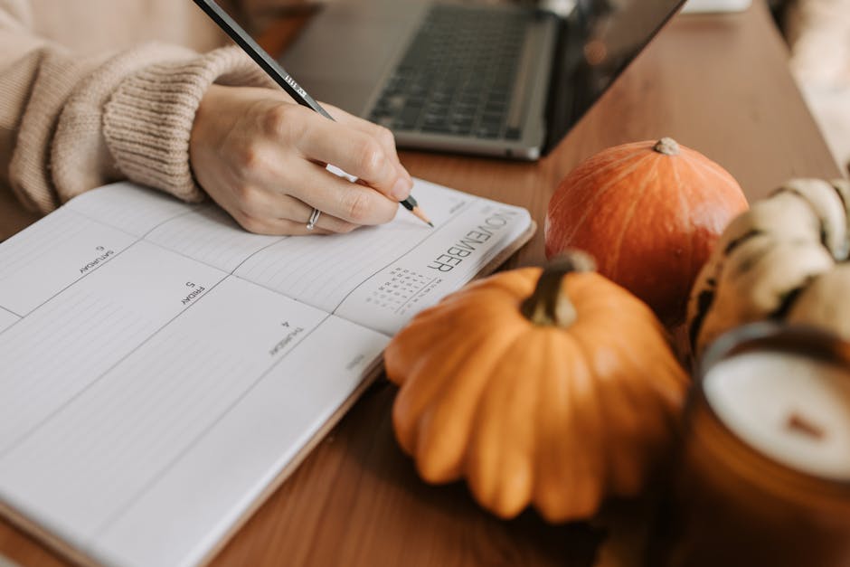 Person organizing tasks with notebook, laptop and calendar