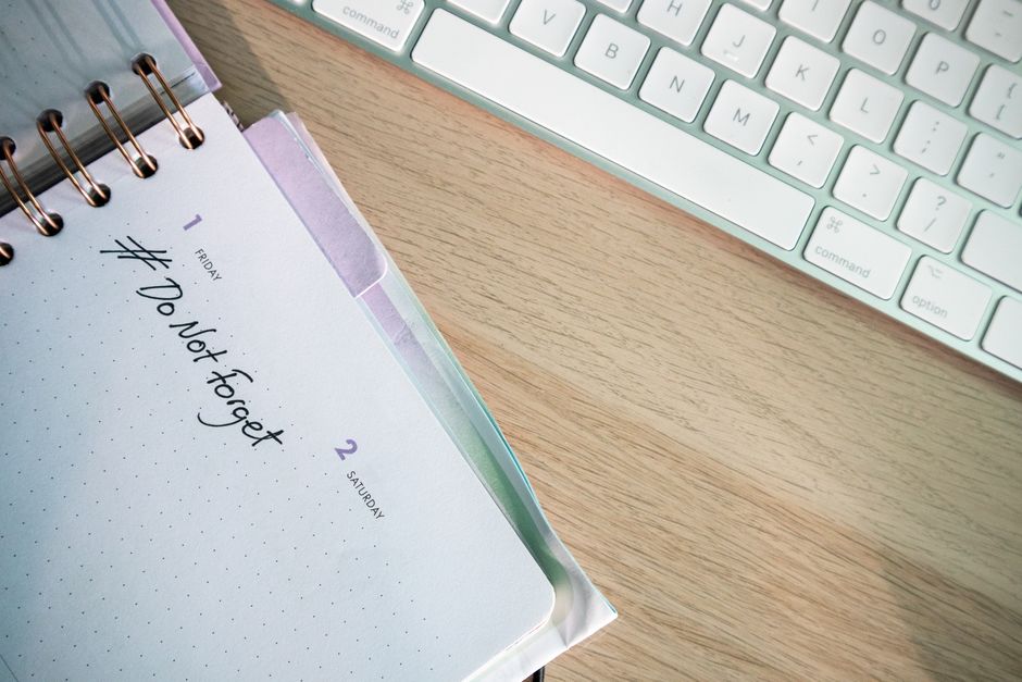Employee tracking work hours on a calendar and notebook