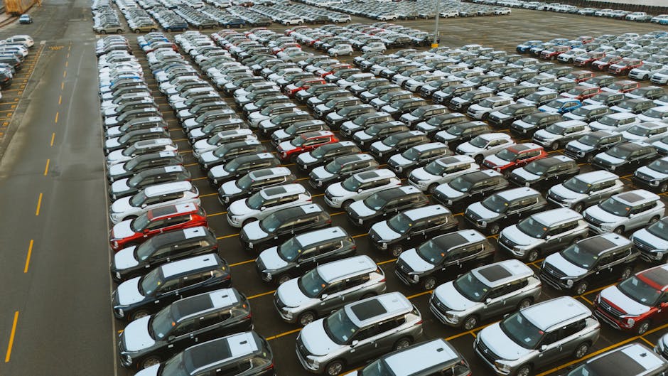 Flotte de voitures de société thermiques et électriques sur un parking d'entreprise