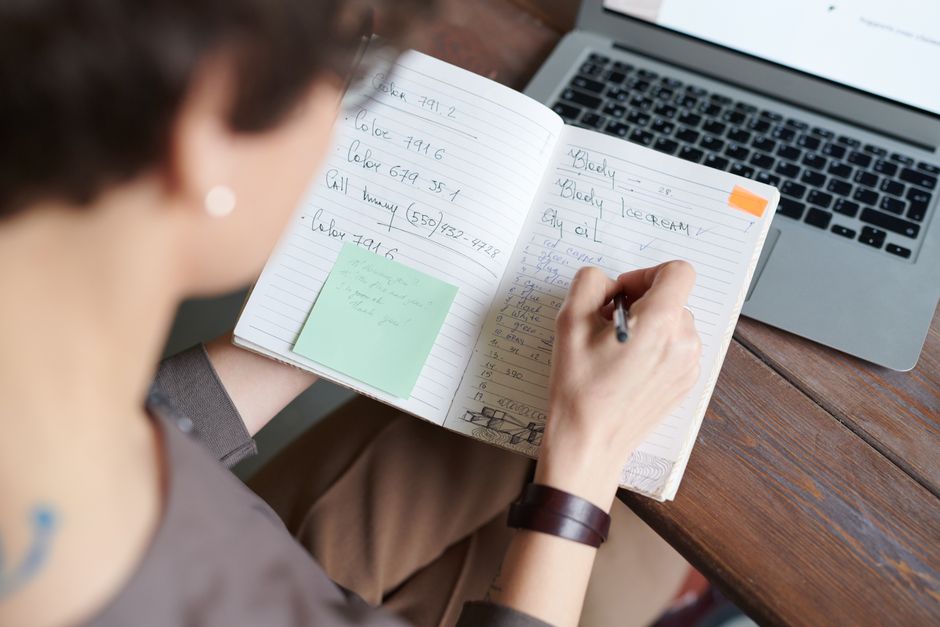 Person planning career goals with notebook and laptop, illustrating self-fulfillment and development