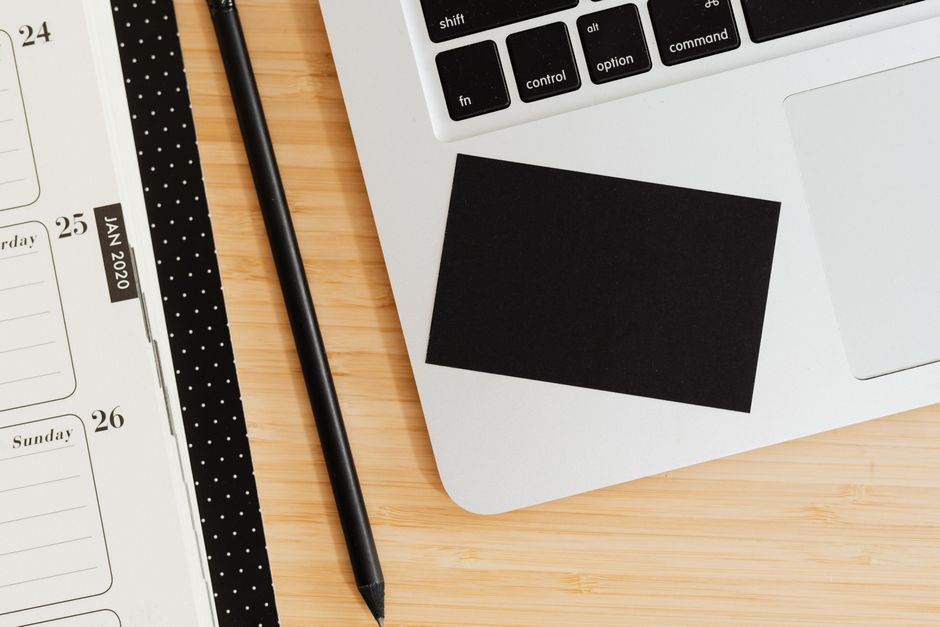 Professional workspace with calendar, notebook and laptop for task prioritization
