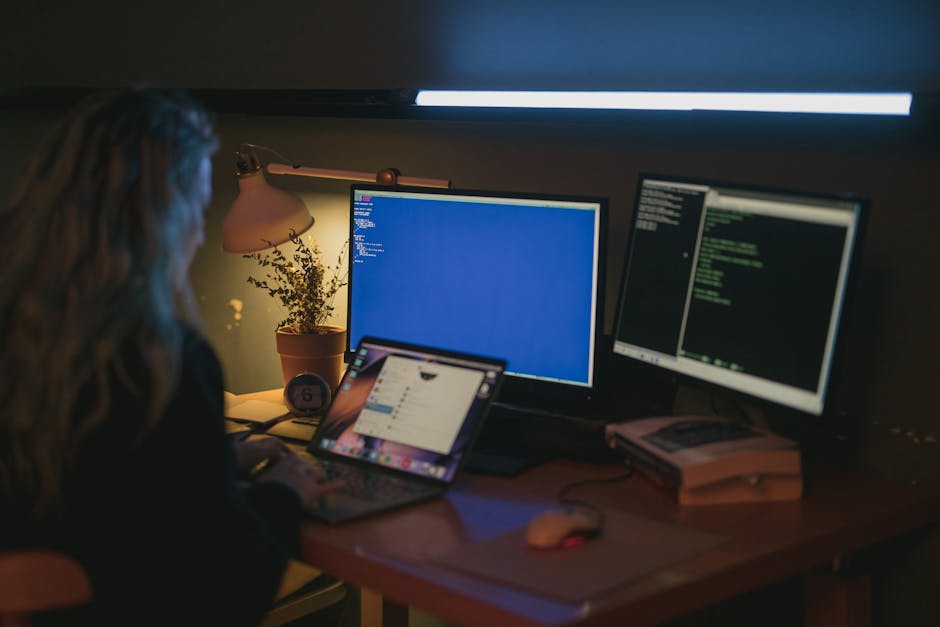 Professionnel travaillant sur un ordinateur avec code et outils techniques
