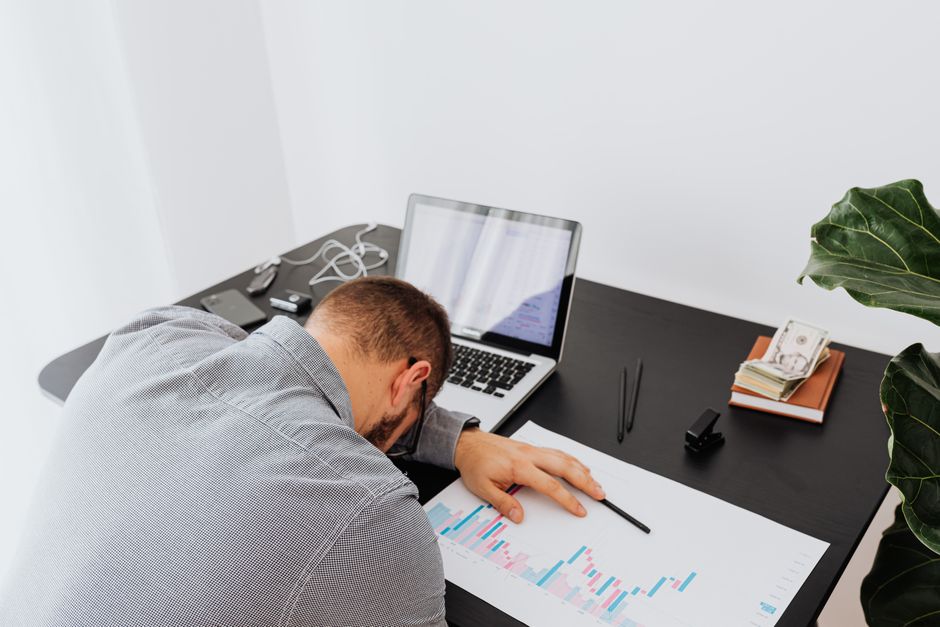 Burnout stressed professional at desk in dim office