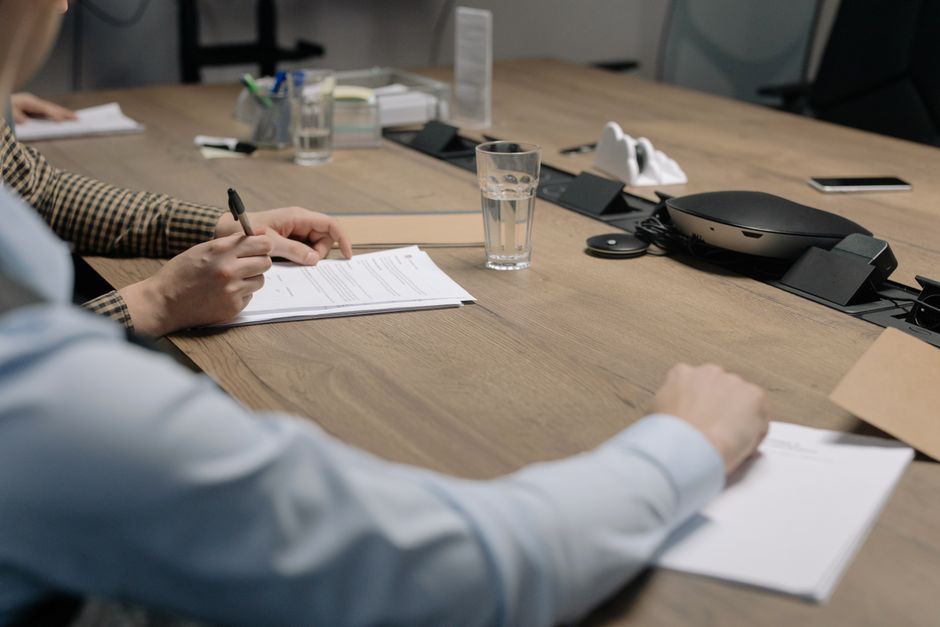 Équipe RH en réunion autour d’un ordinateur avec documents de politique interne