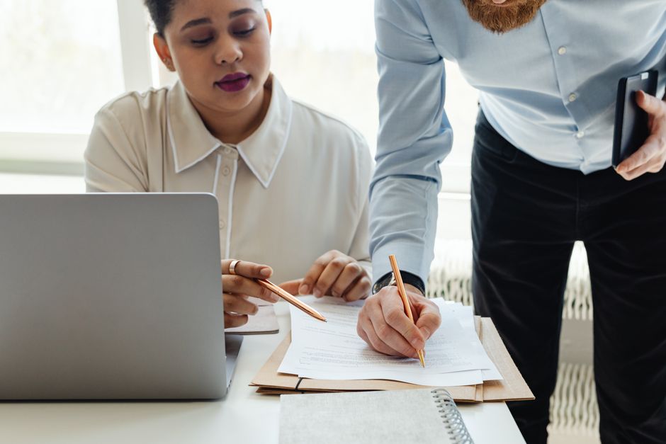 Two colleagues discussing an employment agreement in an office