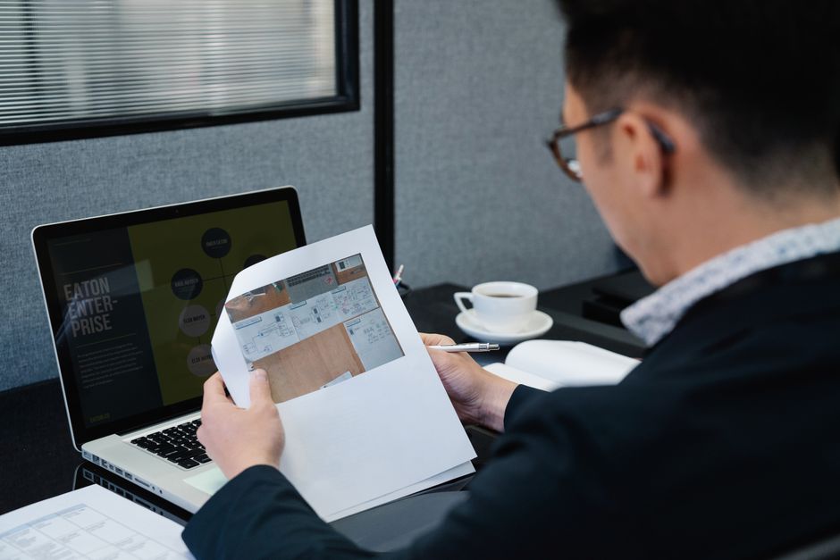 Professional reviewing career development documents with notes and laptop
