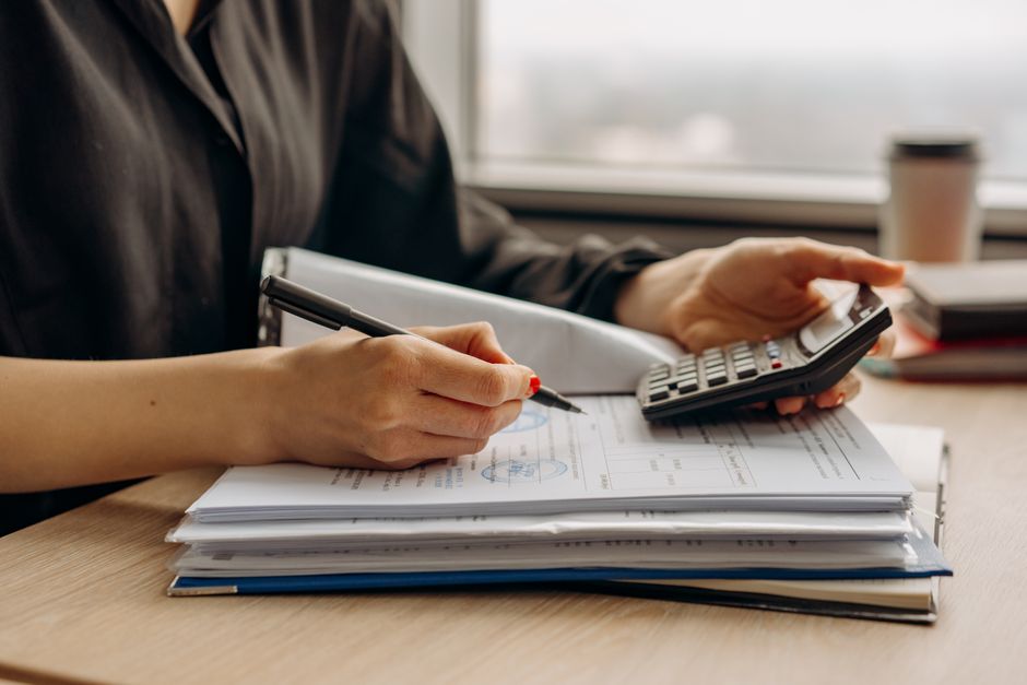 Business professional calculating finances with documents and calculator