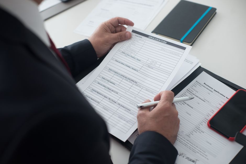 Recruiter reviewing a CV on a laptop in a modern office