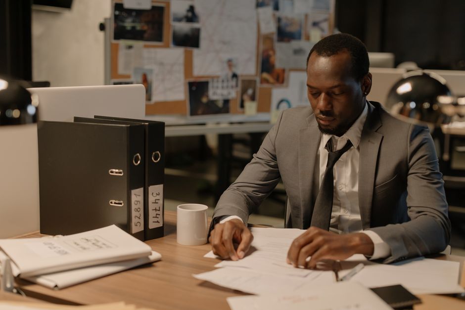 Cadre working late at office with laptop and documents