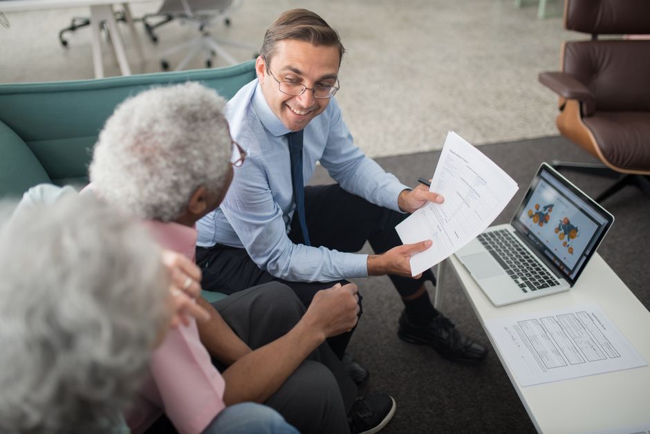 Senior couple reviewing insurance and pension options with advisor
