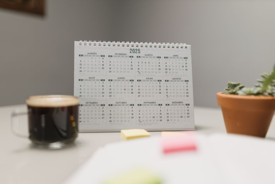 Jours fériés de mai : 4 dates, une seule paie double A 2025 desk calendar with coffee and succulent, ideal for planning and office decor.