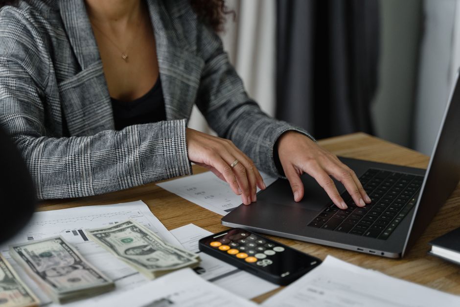 Augmentation individuelle ou collective : le duel sur 35 000 euros A businesswoman working on finance management with cash and calculator on desk.
