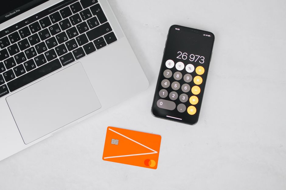 Titres-restaurant : 7,32 € d’exonération, pas 25 € dans la poche A laptop, smartphone displaying calculator, and credit card on a white table.