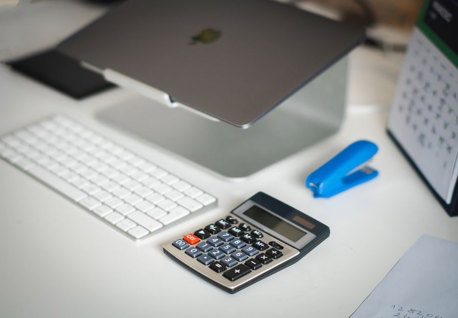 Forfait jours cadre : 218 jours, combien d’heures? A tidy office desk featuring a laptop, calculator, keyboard, and calendar for business planning.