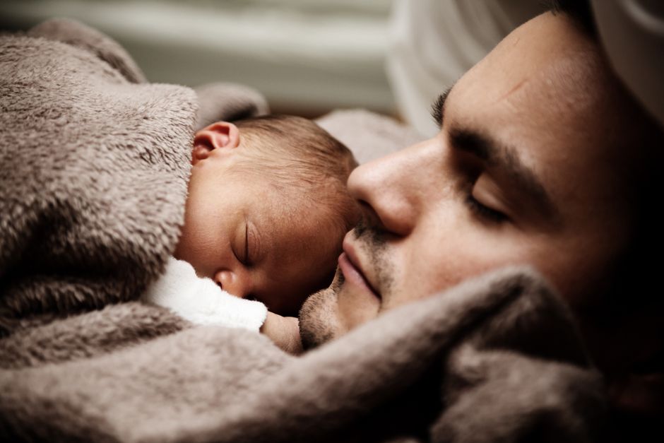 Congé paternité 2026 : 28 jours au total et jusqu’à 2 mois en plus A touching close-up of a father and his baby peacefully napping together.