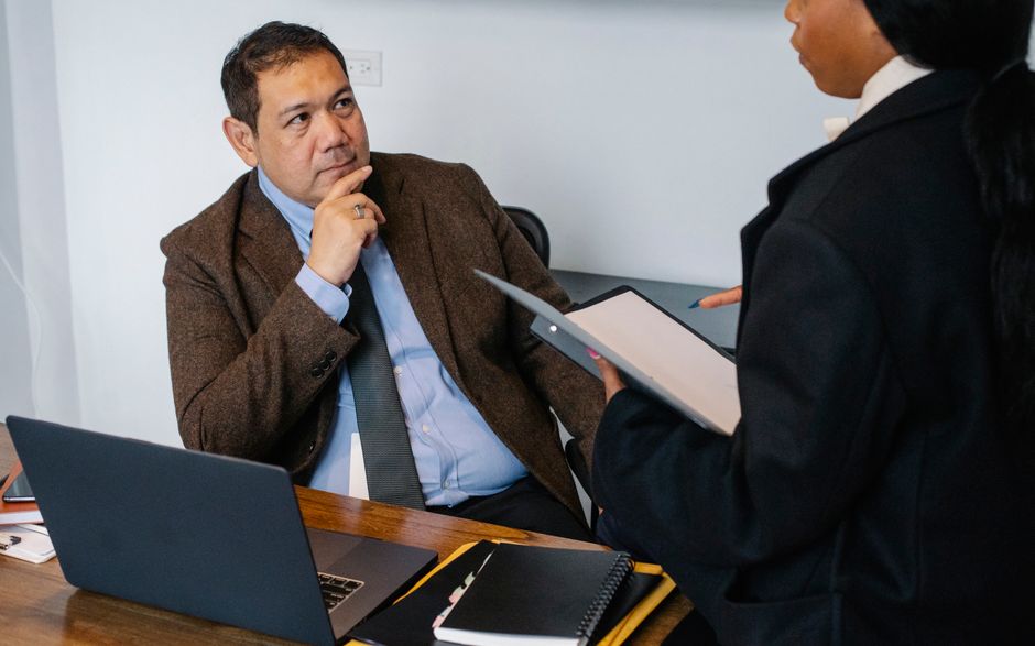 Augmentation refusée : 6 leviers pour négocier autrement African American female office worker reading report for Asian male manager while working together in contemporary workspace