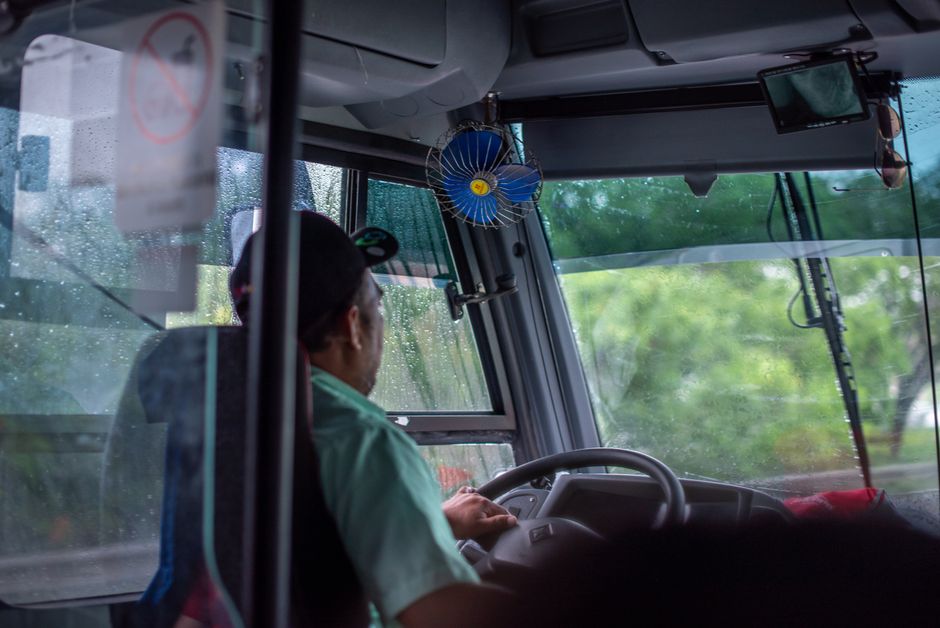 Salaire conducteur RATP : 2 709 euros brut, le bulletin au révélateur Bus driver navigating through rainy weather, view from the interior with visible windshield and raindrops.