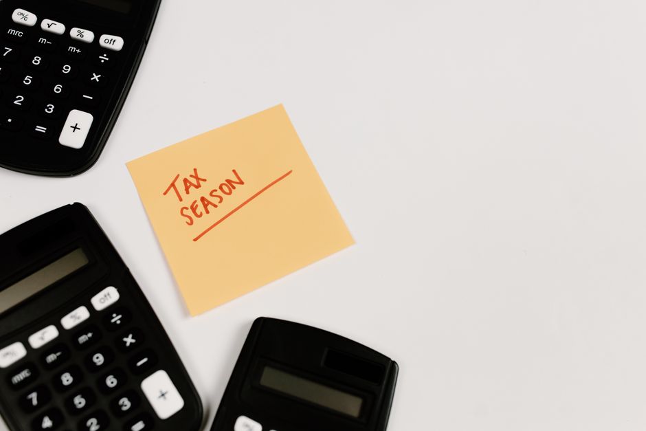 Impôt en retard : 10 %, intérêts et recours, sans doigt mouillé Calculators and sticky note labeled 'Tax Season' on white background, ideal for financial themes.