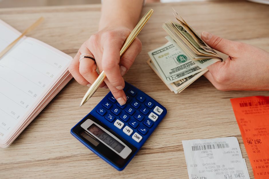 1 216 euros par mois, le seuil de pauvreté ne tient pas sur la fiche de paie Hands handling cash and calculator for budget planning. Modern financial scene.