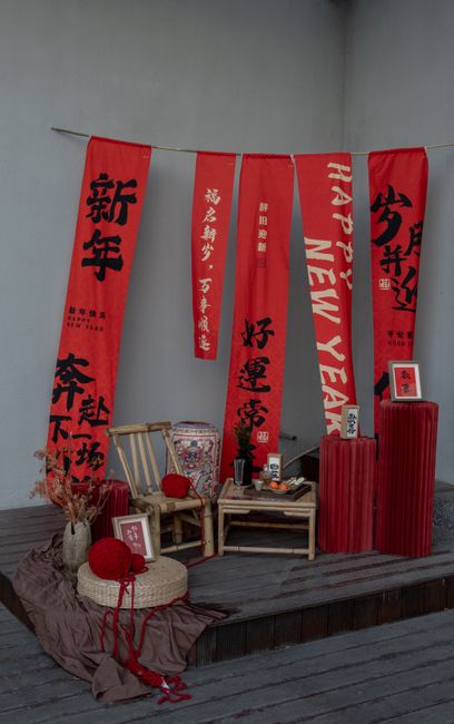 Traditional Asian New Year setup with red banners and decor on a wooden background.
