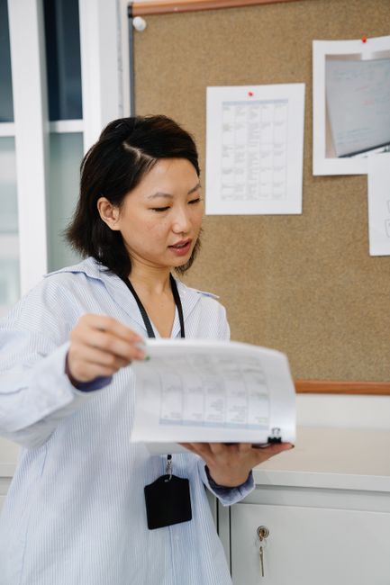 Woman reviewing documents in an office setting, showcasing focus and professionalism.
